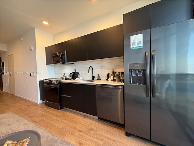398 NE 5th St Unit 2805, Miami, FL 33132 - kitchen featuring stainless steel appliances, a sink, light wood finished floors, light countertops, and backsplash