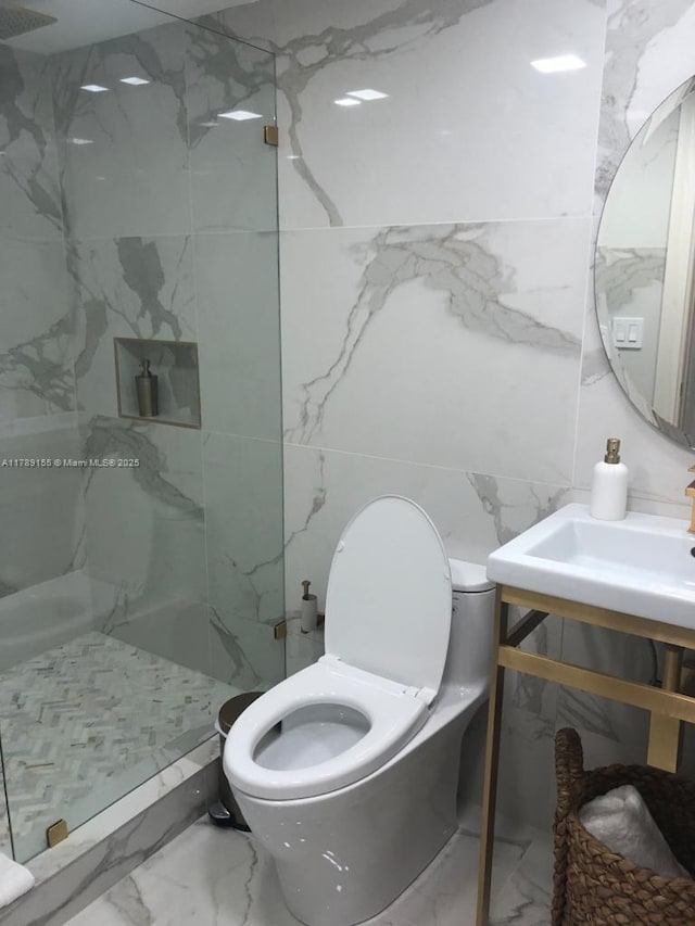 1450 Brickell Bay Dr Unit 1709, Miami, FL 33131 - full bath with a marble finish shower, vanity, tile walls, marble finish floor, and toilet