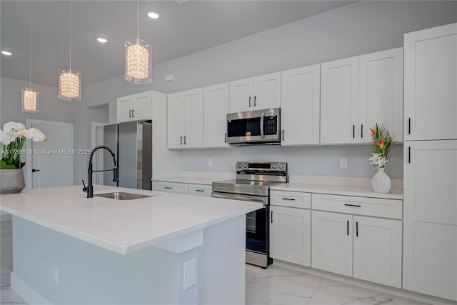 kitchen featuring recessed lighting, white cabinets, marble finish floor, stainless steel appliances, and a kitchen island with sink