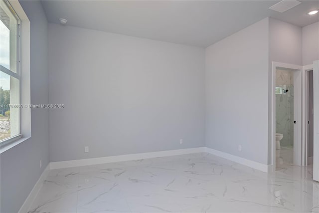 empty room featuring marble finish floor and baseboards