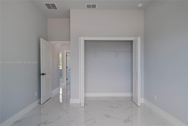 unfurnished bedroom with baseboards, visible vents, marble finish floor, and a closet