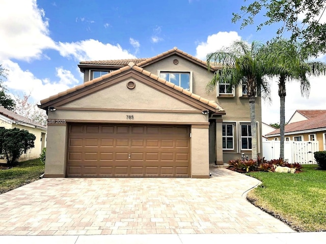 785 Falling Water Rd, Weston, FL 33326 - mediterranean / spanish house featuring fence, a tiled roof, stucco siding, decorative driveway, and a garage