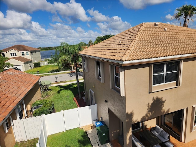 785 Falling Water Rd, Weston, FL 33326 - view of side of home featuring a lawn, a tiled roof, stucco siding, and fence