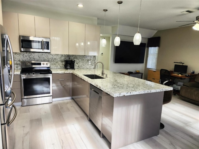 785 Falling Water Rd, Weston, FL 33326 - kitchen with a sink, open floor plan, light wood-style flooring, a peninsula, and appliances with stainless steel finishes