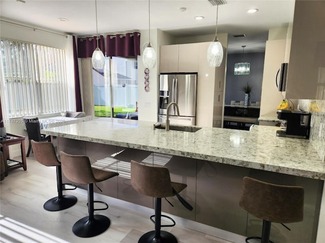 785 Falling Water Rd, Weston, FL 33326 - kitchen featuring a sink, a breakfast bar area, pendant lighting, a peninsula, and appliances with stainless steel finishes