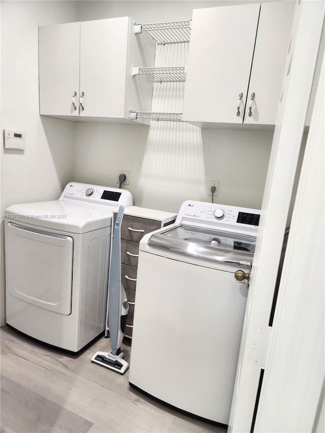 785 Falling Water Rd, Weston, FL 33326 - washroom with washing machine and clothes dryer, light wood-style floors, and cabinet space