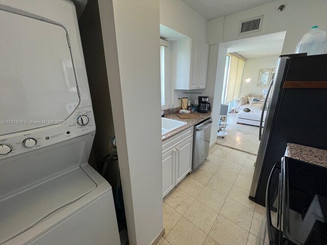 5900 Collins Ave Unit 1505, Miami Beach, FL 33140 - kitchen featuring stainless steel appliances, electric panel, white cabinets, a sink, and a textured ceiling