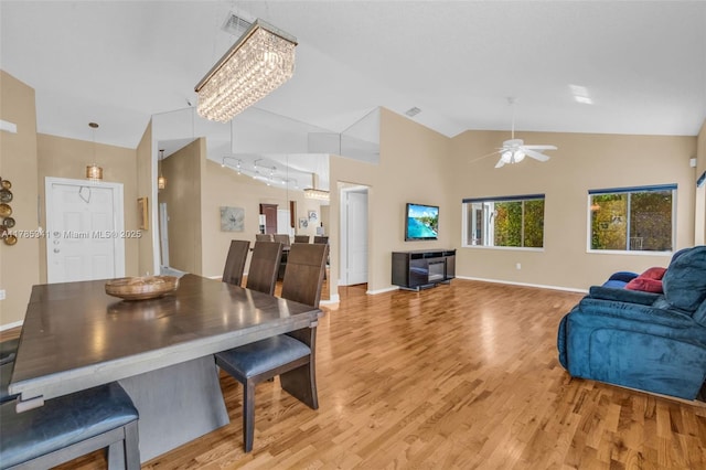 dining space with high vaulted ceiling, light wood finished floors, baseboards, and ceiling fan