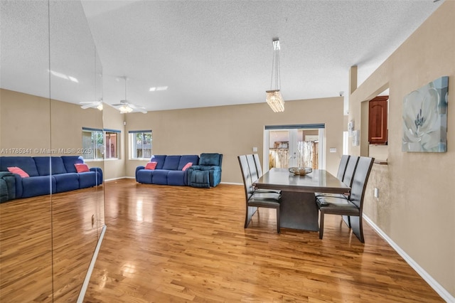 dining area featuring a ceiling fan, baseboards, a textured ceiling, and light wood-style floors