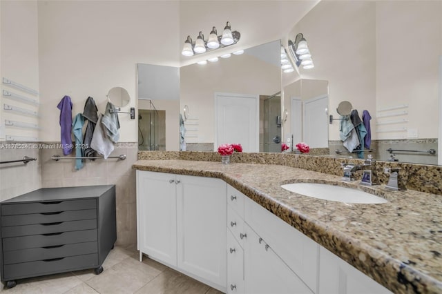 bathroom with tile walls, tile patterned floors, vanity, and a shower stall