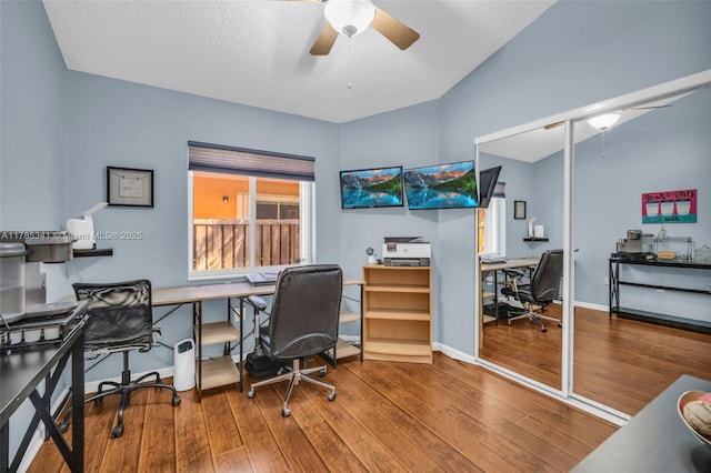office area featuring vaulted ceiling, a ceiling fan, wood finished floors, and baseboards