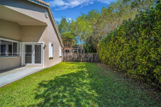 view of yard featuring fence, a patio, and french doors