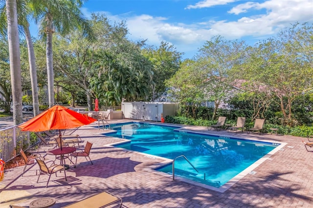 community pool with fence and a patio area