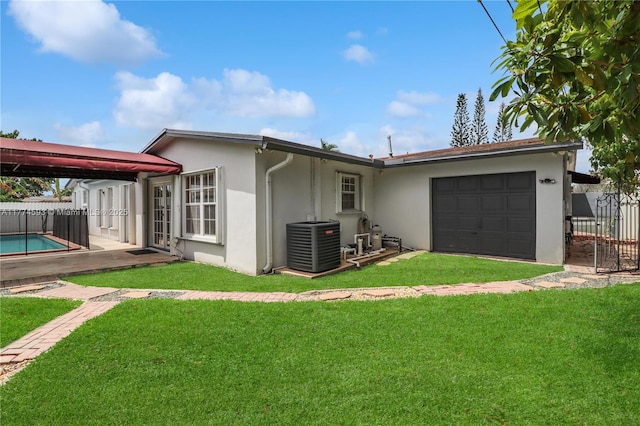 6051 SW 110th Ave, Miami, FL 33173 - rear view of property with fence, a garage, stucco siding, cooling unit, and a lawn