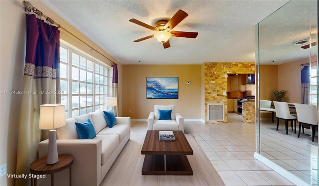 6051 SW 110th Ave, Miami, FL 33173 - living area featuring a ceiling fan, a textured ceiling, light tile patterned floors, and a healthy amount of sunlight
