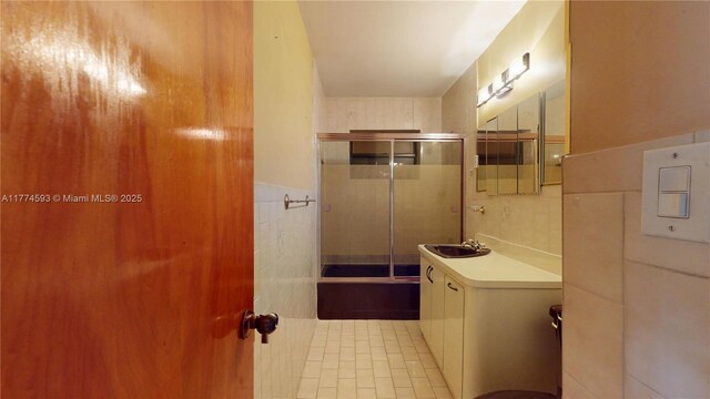 6051 SW 110th Ave, Miami, FL 33173 - bathroom featuring tile walls, a shower with shower door, vanity, and a wainscoted wall