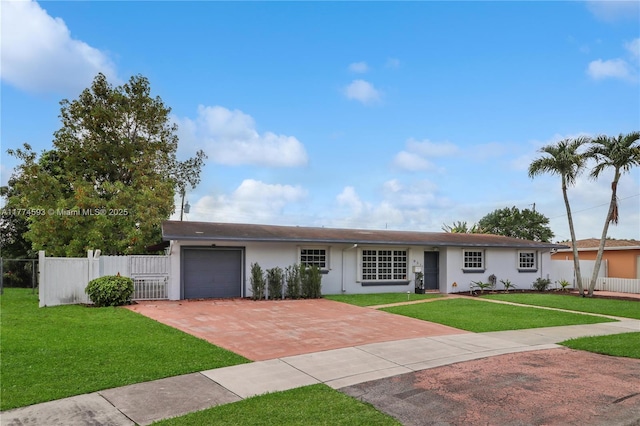 6051 SW 110th Ave, Miami, FL 33173 - ranch-style house featuring a garage, a front lawn, fence, decorative driveway, and stucco siding