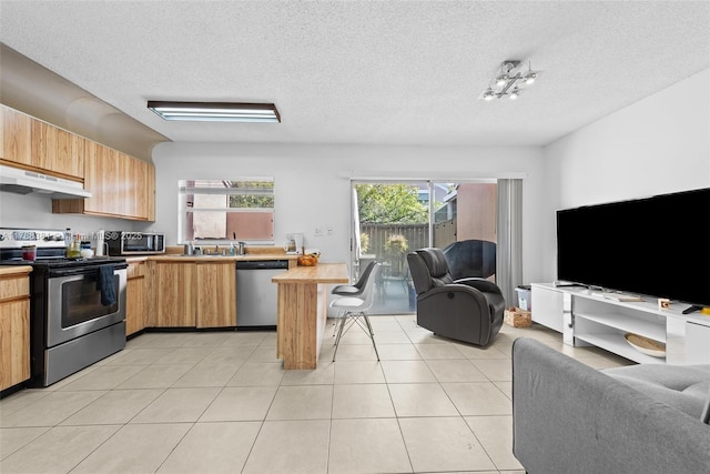 1341 NW 123rd Ter Unit 1341, Pembroke Pines, FL 33026 - kitchen with under cabinet range hood, light countertops, a peninsula, appliances with stainless steel finishes, and open floor plan