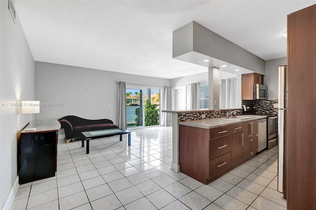 2200 S Ocean Dr Unit N116, Hollywood, FL 33019 - kitchen featuring decorative backsplash, light tile patterned flooring, open floor plan, a sink, and appliances with stainless steel finishes