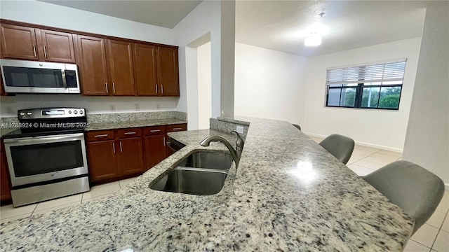 10620 NW 88th St Unit 205, Doral, FL 33178 - kitchen with light stone counters, appliances with stainless steel finishes, a sink, and light tile patterned floors