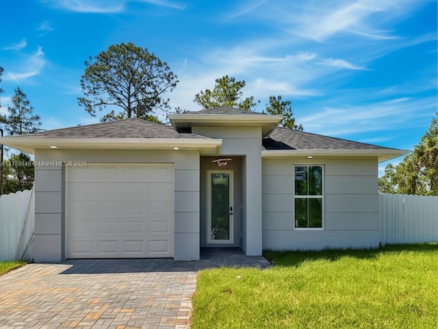 924 Berg St E, Lehigh Acres, FL 33974 - prairie-style home featuring a garage, a front lawn, fence, and stucco siding