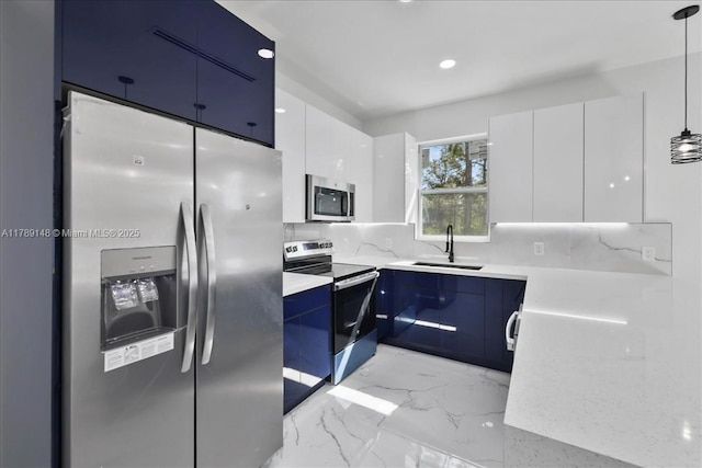 924 Berg St E, Lehigh Acres, FL 33974 - kitchen with blue cabinetry, appliances with stainless steel finishes, white cabinets, a sink, and modern cabinets