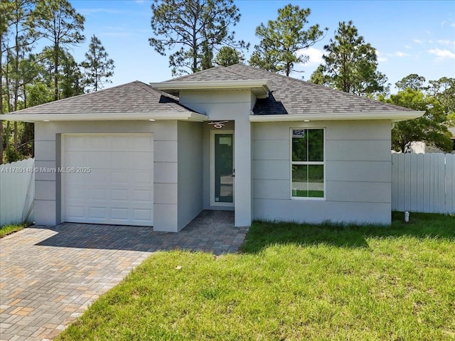 924 Berg St E, Lehigh Acres, FL 33974 - view of front of house featuring a front yard, a shingled roof, a garage, stucco siding, and fence