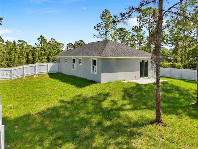 924 Berg St E, Lehigh Acres, FL 33974 - rear view of property with stucco siding, roof with shingles, a yard, and a fenced backyard