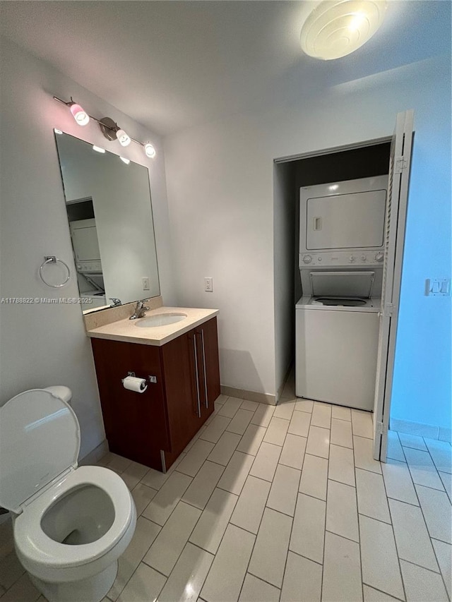 79 SW 12th St Unit 2703-S, Miami, FL 33130 - bathroom featuring stacked washer and clothes dryer, tile patterned floors, vanity, and toilet