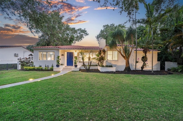 558 NE 94th St, Miami Shores, FL 33138 - mediterranean / spanish house with a front lawn, a tile roof, a chimney, and stucco siding