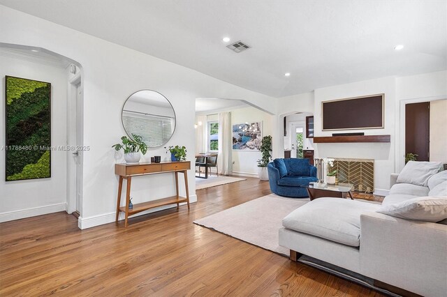 558 NE 94th St, Miami Shores, FL 33138 - living room with arched walkways, wood finished floors, recessed lighting, and a fireplace
