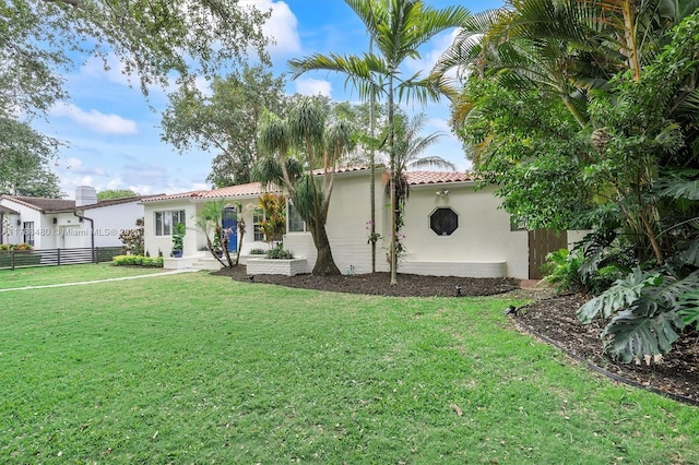 558 NE 94th St, Miami Shores, FL 33138 - view of front of house featuring fence, a tile roof, a front yard, and stucco siding