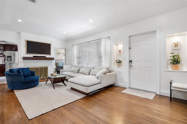 558 NE 94th St, Miami Shores, FL 33138 - living area featuring wood finished floors, a fireplace with flush hearth, and recessed lighting