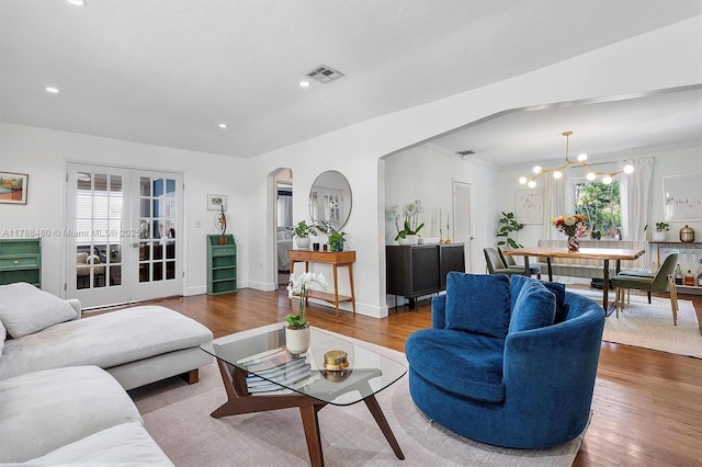 558 NE 94th St, Miami Shores, FL 33138 - living room featuring french doors, arched walkways, visible vents, a notable chandelier, and wood finished floors