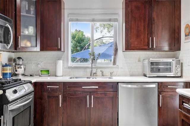 558 NE 94th St, Miami Shores, FL 33138 - kitchen with a sink, decorative backsplash, a toaster, stainless steel appliances, and light countertops