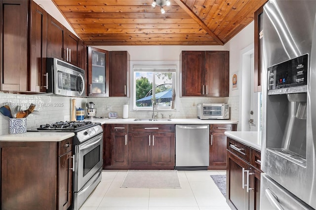 558 NE 94th St, Miami Shores, FL 33138 - kitchen with stainless steel appliances, a sink, vaulted ceiling, decorative backsplash, and wood ceiling