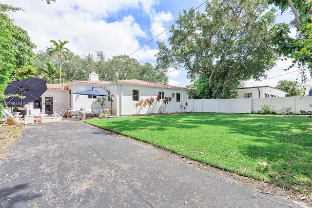 558 NE 94th St, Miami Shores, FL 33138 - view of front facade featuring a tile roof, a chimney, fence, a front yard, and stucco siding