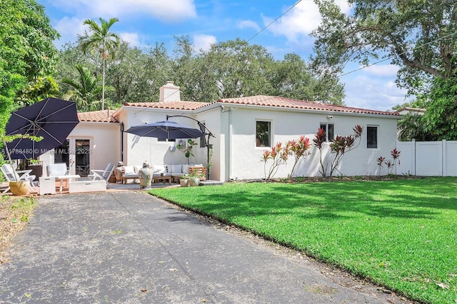 558 NE 94th St, Miami Shores, FL 33138 - rear view of property with a tile roof, a lawn, a chimney, and an outdoor living space