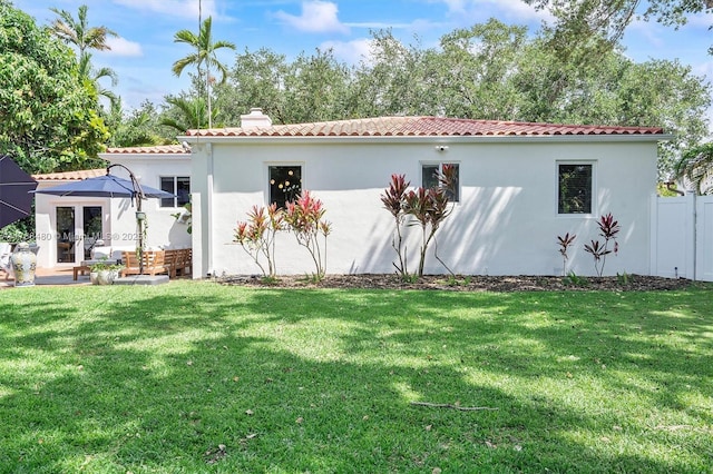 558 NE 94th St, Miami Shores, FL 33138 - back of property with a chimney, a tile roof, a yard, and stucco siding