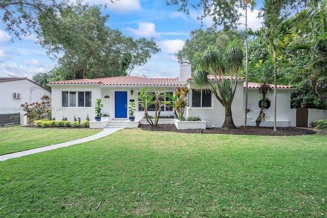 558 NE 94th St, Miami Shores, FL 33138 - view of front of house featuring a tile roof, a chimney, a front yard, and stucco siding
