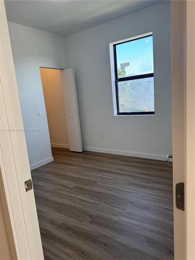 1037 NW 1st Ave Unit A, Florida City, FL 33034 - unfurnished bedroom featuring dark wood finished floors and baseboards