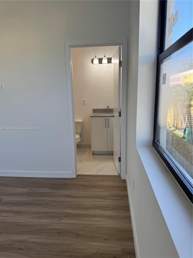 1037 NW 1st Ave Unit A, Florida City, FL 33034 - corridor featuring baseboards, a sink, and plenty of natural light