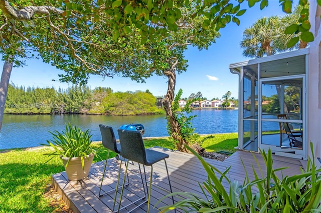 dock area featuring a lawn and a deck with water view