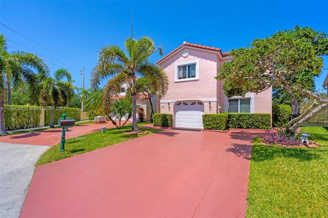 mediterranean / spanish home featuring a tile roof, a front lawn, concrete driveway, an attached garage, and stucco siding