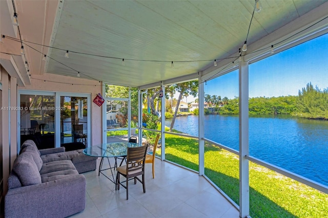 sunroom / solarium with plenty of natural light, french doors, and a water view