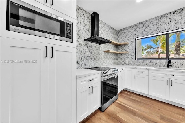15020 NE 7th Ave, Miami, FL 33161 - kitchen featuring wall chimney exhaust hood, stainless steel appliances, a sink, light wood-style floors, and light countertops