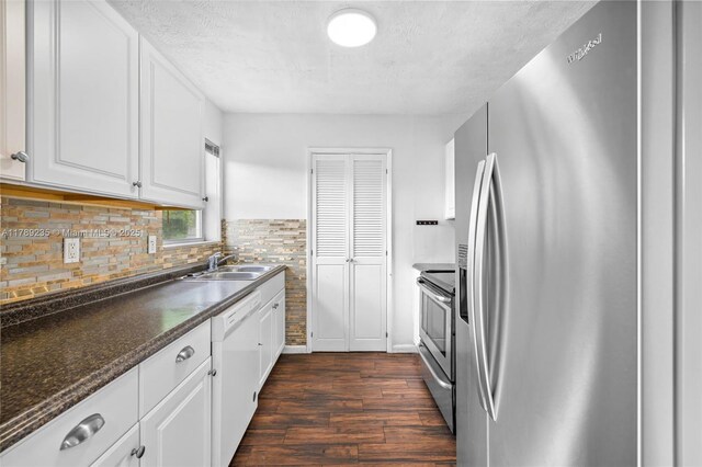 1920 N 66th Ave, Hollywood, FL 33024 - kitchen featuring appliances with stainless steel finishes, tasteful backsplash, dark wood finished floors, a sink, and white cabinetry