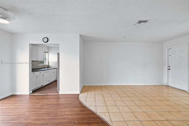 1920 N 66th Ave, Hollywood, FL 33024 - interior space with visible vents, baseboards, light wood-type flooring, a textured ceiling, and a sink