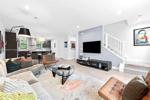 living room featuring stairway, baseboards, light tile patterned flooring, and recessed lighting