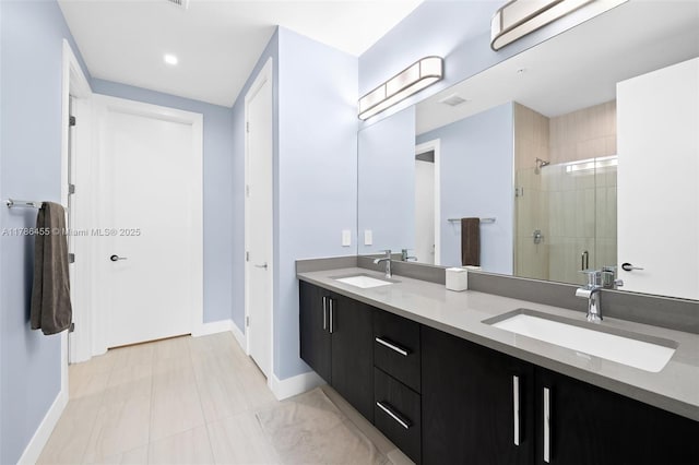full bath with baseboards, a sink, double vanity, and a stall shower